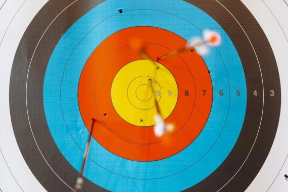 Close-up of a colorful archery target with perfectly hit arrows showcasing precision.